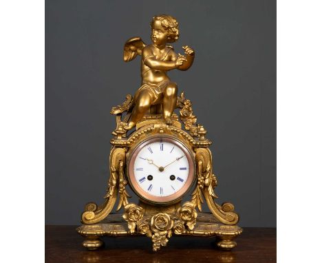 A gilt Spelter mantle clock, possibly French, topped with a figure of a cherub covered in scrolling and floral decoration, th