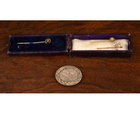 A Victorian silver brooch with engraved swallow decoration, 4cm diameter, together with three stick pins, two with gold colou