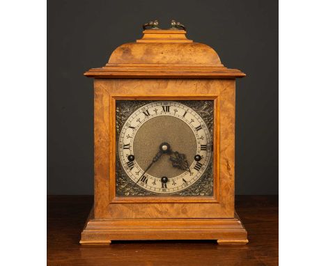 A 1940's Smith's walnut and mahogany cased mantle clock the silvered surround to the metal dial marked with roman numerals, w