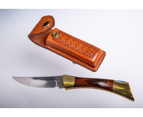Jagdmesser (Browning, USA), Holzgriff, Metallbeschläge, klappbar, Lederetui m.Reliefdekor, L. ca. 23 cm. Gebrauchsspuren.