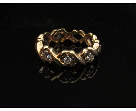 A gold eternity ring with seven diamonds set in open X settings, stamped 14k. Size M, 4.5g