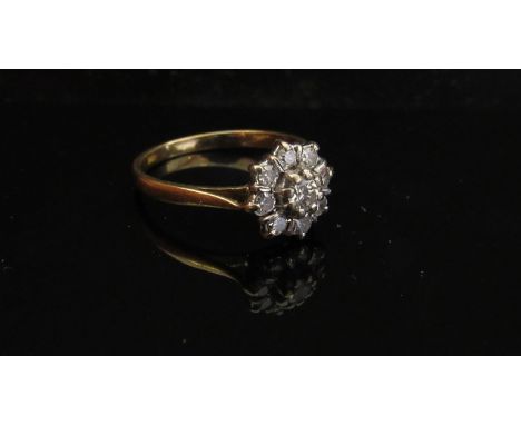 An 18ct gold diamond daisy ring. Size L/M, 2.6g