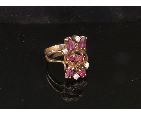 A gold diamond and ruby cluster ring in split shoulders, stamped 10k. Size O, 3.5g