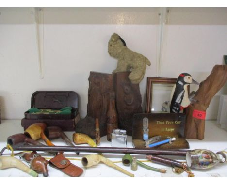 A carved and painted figure of a woodpecker on a tree trunk, carved book ends, vintage darts, pipes and other items. Location