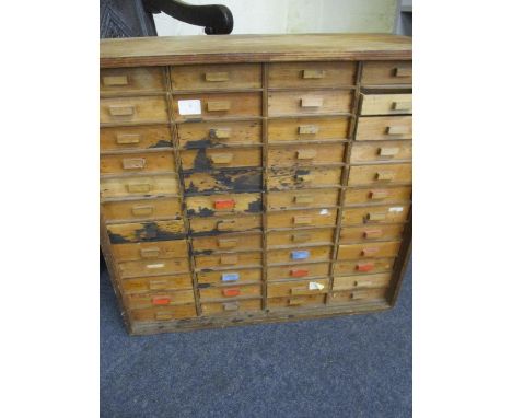 A vintage plywood collectors chest with drawers to the front and back and side handles 