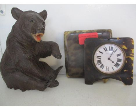 A Black Forest carving of a bear, teeth showing, together with a luminous dial bedside clock in a tortoiseshell case, A/F 