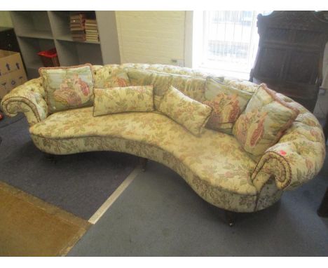 A bespoke made curved button upholstered sofa, on turned mahogany finished legs, 65cm high x 250cm wide 