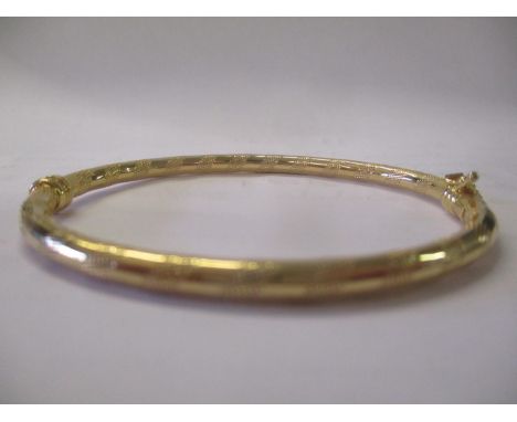 A 9ct gold bangle with engraved decoration 4.1g 