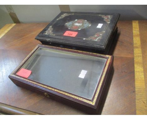 An early 20th century gilt burgundy leather covered box with a glazed lid, and a late 19th century brass and mother of pearl 