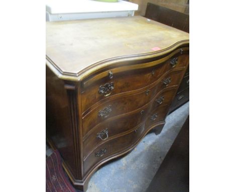 A reproduction serpentine fronted gentleman's dressing chest with brushing slide, four graduated drawers flanked by fluted co
