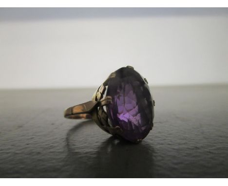 A rose gold coloured amethyst ring with remains of a gold over wash, claw set oval amethyst coloured stone, 7/8g, total weigh