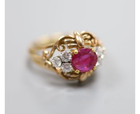   A stylish yellow metal, ruby and diamond set cluster  ring, with single round cut ruby(crack), flanked by six round cut dia