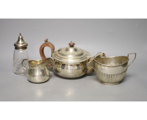   A George V silver teapot, Birmingham, 1913, a similar cream jug and sugar bowl and a silver mounted glass sugar sifter,weig