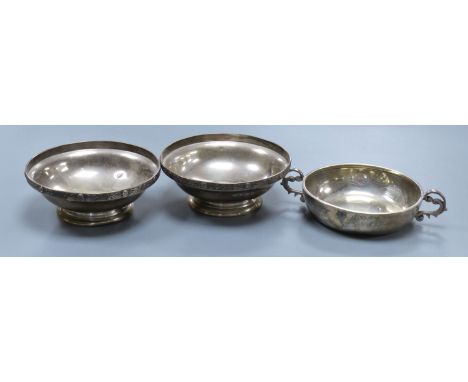   A pair of George VI silver pedestal nut dishes, Birmingham, 1939, 10.8cm and a similar two handled dish,7oz.