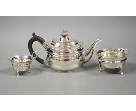   A George V silver teapot with floral finial, London, 1927 together with an associated cream jug, Chester 1907 and an Art De