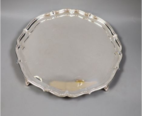   A circular silver salver,having piecrust border on four scrolled feet, Birmingham 1936, 36cm, 37oz.