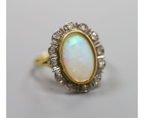   An 18ct, white opal and illusion set diamond oval cluster ring (one diamond missing),size P/Q, gross weight 5.8 grams.