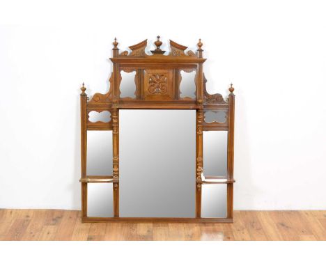 An Edwardian mahogany overmantel mirror, the central finial set with a pediment top flanked by four further finials, over a c