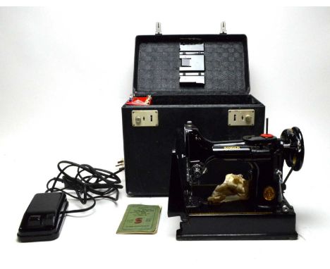 A Singer 221K Portable electric sewing machine, with manual, in carry case.