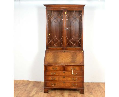 A good quality Georgian style mahogany bureau bookcase, the flared cornice over two glazed astragal doors enclosing adjustabl