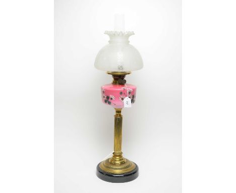A Victorian brass oil lamp, with enamelled pink ombre glass reservoir, frosted glass shade, clear glass funnel, 75cms high ov