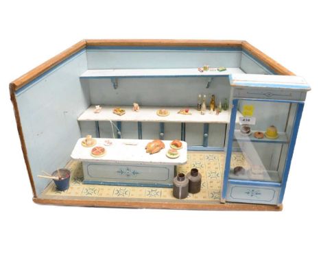 A vintage painted wood dolls house interior, modelled as a shop front, with floating island, dressed with groceries including