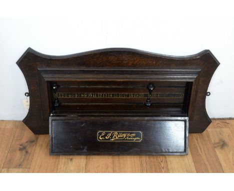 A vintage stained oak billiards/snooker scoreboard by E.J Riley of Accrington; the shield-shaped back and raised centre with 