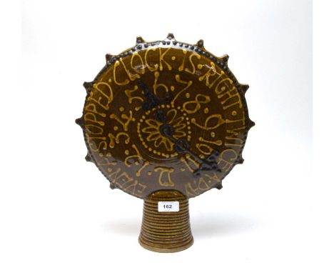 A retro 1970s studio pottery clock sculpture, inscribed ‘Even a stopped clock is right twice a day’, 37cms high.