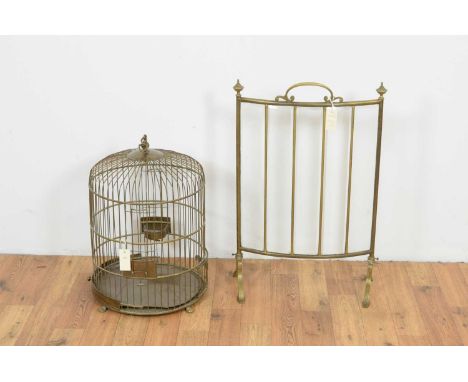 An unusual early 20th Century curved brass firescreen, the shaped handle flanked by finials, over bevelled glass panels raise