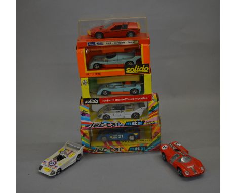 Five boxed diecast model cars in 1:43 scale including two by Norev - #813 Lola and #834 Chevron, two by Solido - #17 Gulf Mir