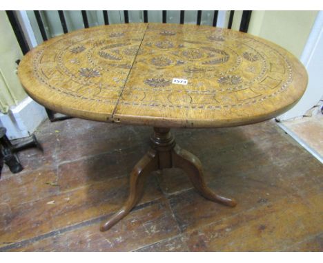 A 19th century oak occasional table, the oval top with geometric chip carved detail, raised on a turned pillar and tripod bas