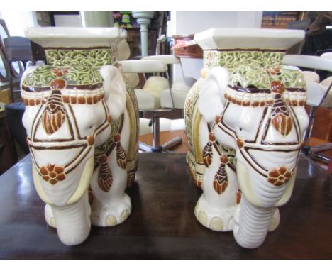 A pair of contemporary glazed ceramic garden seats in the form of elephants with decorative and painted head dress 