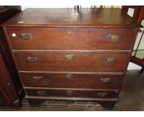 An 18th century oak country made chest with rising lid, the front elevation presented as four long drawers (two false and two