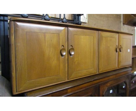 An Ercol medium elm wall cabinet enclosed by four rectangular doors with dished handles, together with a matching open plate 