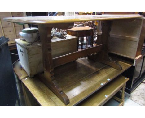 An Ercol medium elm refectory table of rectangular form with moulded outline and rounded corners raised on a pair of vase sha