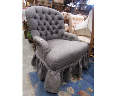A Victorian style low button back bedroom/drawing room chair with shaped outline, upholstered finish and  turned forelegs