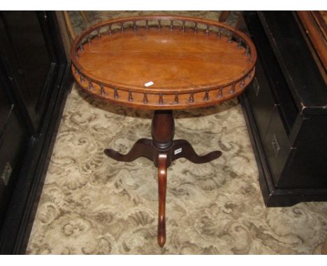 A Georgian style mahogany occasional table, the oval tray top with open baluster gallery raised on a vase shaped pillar and t