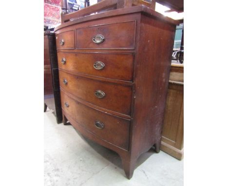 An early 19th century mahogany bow fronted bedroom chest of three long and two short graduated drawers with shaped apron and 