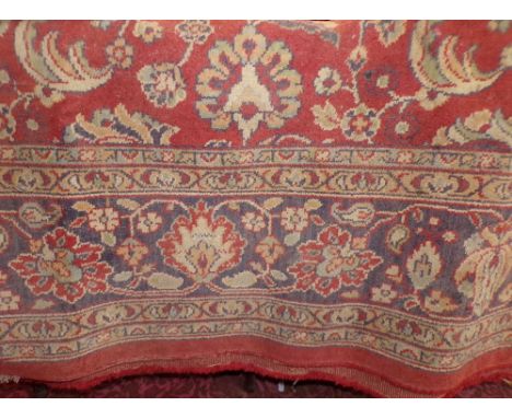 A Belgian cotton carpet in the Persian style with floral detail within running borders