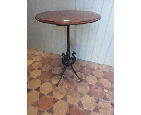 A Victorian cast iron table base with fluted column and swept tripod supports with dragons head and paw feet, beneath a later