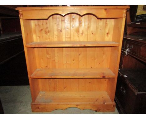 A stripped pine floor standing open bookcase with two fixed shelves, together with a further pine dresser rack, with shaped o