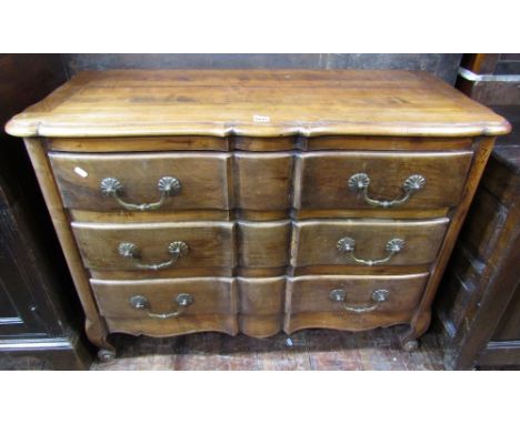 A French fruitwood commode of three long drawers with shaped outline on short cabriole supports, 108cm wide