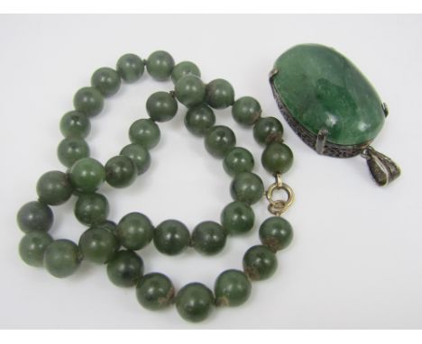 A spinach jade bead necklace with gold clasp, together with a green hardstone pendant in openwork mount