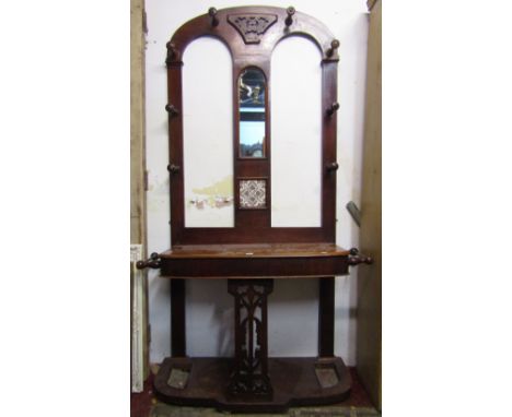 A Victorian mahogany hall stand of full height, the raised arched back incorporating a central mirror plate and transfer prin