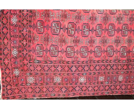 An Afghan red wool carpet with geometric detail, principally in  black, red and white colourway, 120 x 220 cm