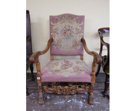 A scroll armed elbow chair in beechwood, with hand worked tapestry seat and back, raised on lion paw supports