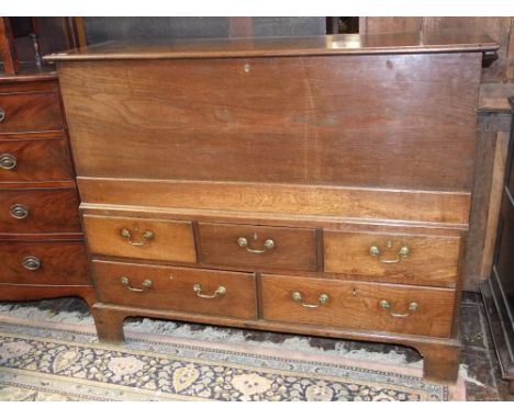 A Georgian oak linen chest, the lower section enclosed by an arrangement of two long and three short drawers, the upper secti