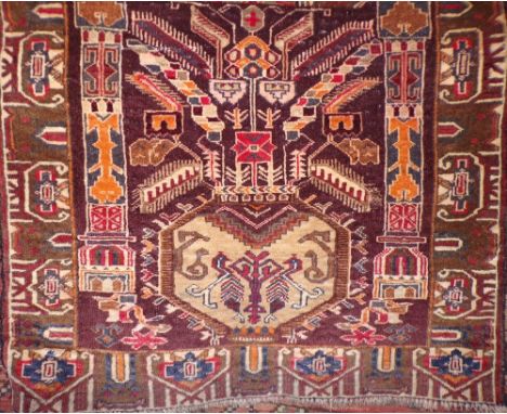 An Eastern wool carpet with chocolate coloured ground, triple medallion centre within running borders, all on a geometric lin