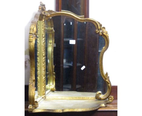 A gilt framed wall mounted corner shelf, incorporating two mirror panels within a scrolled acanthus framework