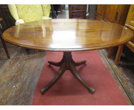 A Regency mahogany supper table, the oval top with cross banded borders, with boxwood and string ebony inlay, raised on a tur